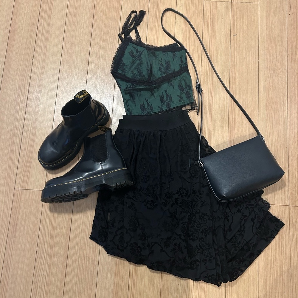 Plus size, 90s inspired, crop top. It is a dark green with a black lace overlay.